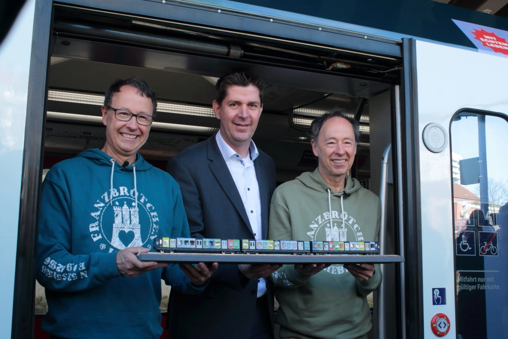 Frederik Braun, Jan Schröder und Gerrit Braun präsentieren das Modell des Jubiläumszuges